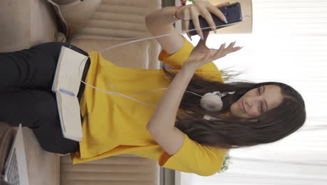Vertical-video-of-Female-student-using-phone-while-dancing.